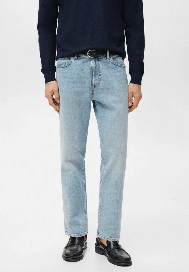 Vaqueros de mezclilla azul claro con corte recto, diseño de cinco bolsillos y costuras en contraste, combinados con un suéter oscuro y zapatos negros.