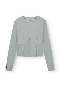 Lange mouwen, cropped top van lichtgroene stof met een gladde textuur. Heeft een centrale naad en een subtiele kromming bij de borst.