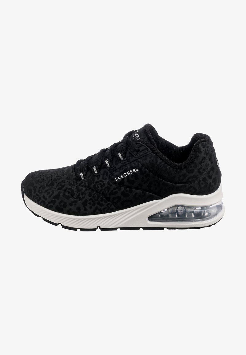 Sneakers noirs Skechers avec un imprimé léopard discret, une semelle intermédiaire blanche, un coussin d'air visible et des lacets noirs.
