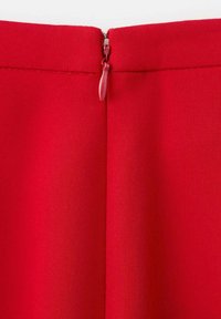 Red fabric with a smooth texture and visible seam. Features a centered zipper at the back, including a red zipper pull.