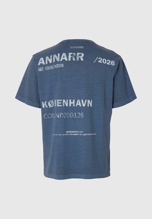 T-shirt bleu avec texte blanc faisant référence à la ANNARR Art Foundation, /2026, KØBENHAVN, COLNR000126, et une adresse à Copenhague.