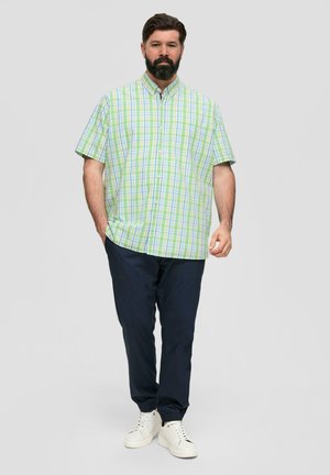 Chemise à manches courtes en coton à carreaux verts et bleus, assortie à un pantalon bleu marine et des baskets blanches. Comprend un col boutonné et une coupe décontractée.