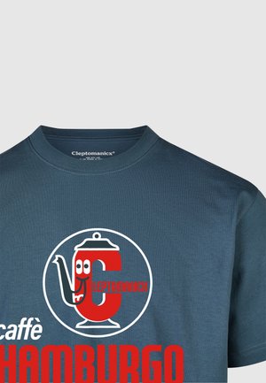 Dunkelblaues Rundhals-T-Shirt mit einem großen roten runden Logo, das eine Teekanne und den Text "Cleptomanick caffè HAMBURGO" zeigt. Glatte Baumwolltextur.