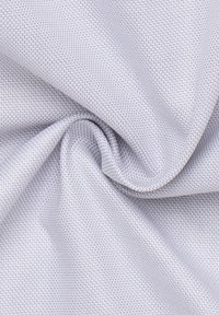 Tessuto testurizzato in grigio chiaro con un piccolo motivo geometrico ripetuto. Liscio, con una leggera lucentezza e una qualità di caduta.