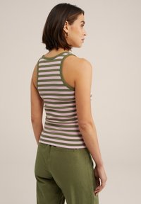 Juostuotas tank top'as, kuriame vyrauja žalios ir rožinės horizontalios juostos, su prigludusia forma ir apvaliu iškirpimu. Papildytas laisvais žaliais kelnėmis.