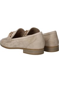 Beige Wildleder Slipper mit niedrigem, gestapeltem Absatz, verziert mit einem dekorativen Akzent aus goldfarbener Hardware und gestickten Details an den Seiten.