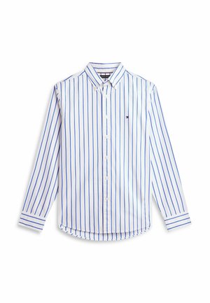 Camicia bianca a maniche lunghe con bottoni, strisce verticali blu e un piccolo logo sul lato sinistro del petto, mostrata stesa su uno sfondo bianco.