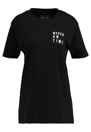 Black cotton T-shirt with short sleeves, round neckline, and white text reading "NEVER ON TIME" printed on the front. Simple design.