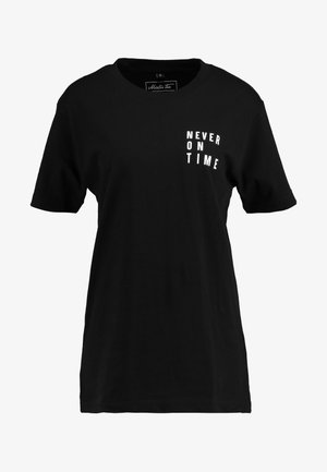 T-shirt di cotone nero con maniche corte, scollatura rotonda e testo bianco che recita "MAI IN TEMPO" stampato sul davanti. Design semplice.