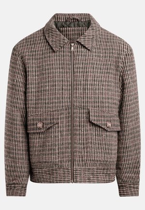 Takki, jossa on houndstooth-kuvio ruskean ja mustan sävyissä, etujalassa vetoketju, kaksi rintataskua ja klassinen kaulusdesign.