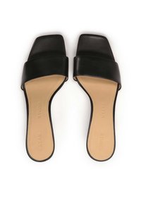 Zwarte slidesandalen met een brede band en vierkante neus. Gladde leren bovenkant en beige binnenzool. Stikdetails langs de rand. Platte zool.
