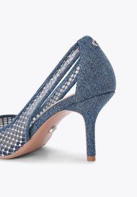 Jeansowe buty na wysokim obcasie z otwartymi bokami, siateczkowym detalem, stożkowym obcasem i błyszczącym metalicznym akcentem z tyłu. Kolor: niebieski i beżowy.