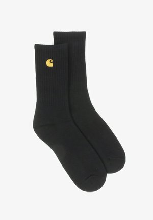Black ribbed socks with a yellow logo on the side. The material is smooth, and the design features a classic crew length.