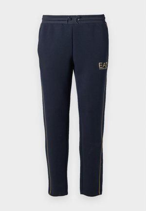 Marina sweatpants i mjukt tyg har dragsko i midjan, gyllene accenter och sidoränder, designade för komfort och mångsidighet.