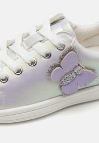 Iridescerande snörningssneakers i ljuslila med vita snören, med en glittrande fjärilsdetalj i nyanser av lila och silver.
