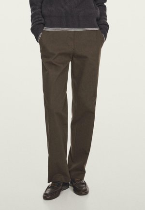 Pantaloni dritti marroni realizzati in tessuto misto cotone, dotati di tasche laterali e passanti per cintura, abbinati a scarpe in pelle scura.