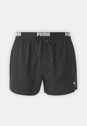 Calções de banho pretos com um cós elástico, apresentando um logo branco "PUMA", cordão de ajuste e um bolso lateral. Textura de tecido suave.