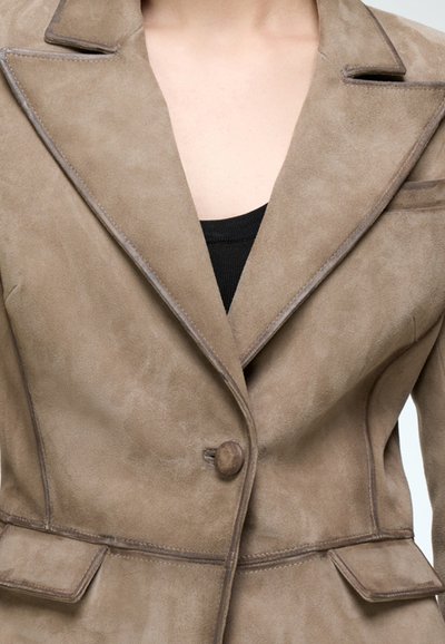 Suede brown blazer with a notched collar, single button closure, and two front pockets. Features subtle stitching and a smooth texture.