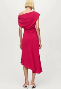 Vestido drapeado asimétrico en tela rosa brillante con un ajuste ligeramente holgado, que presenta un diseño de un solo hombro y un dobladillo fluido.