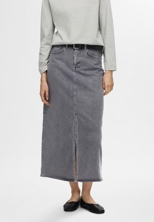 Gray denim maxi skirt with a front slit, finished hem, and two front pockets, paired with a light gray long-sleeve top and black flats.