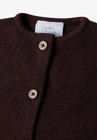 Brauner Strickcardigan mit rundem Halsausschnitt, zwei Knöpfen und einem eingenähten Etikett mit Markennamen. Weiche Textur und klassisches Design.