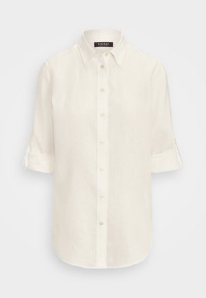 White linen shirt with a pointed collar, button closure, and rolled-up sleeves. Smooth texture, curved hem, and subtle sheen.