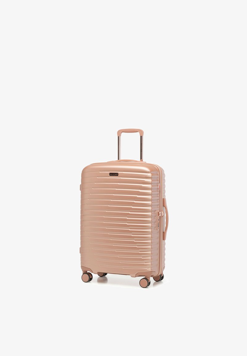 Maleta rígida color oro rosa con cuatro ruedas giratorias, asa telescópica, asa lateral y patrón texturizado de teclas de piano en el frente.