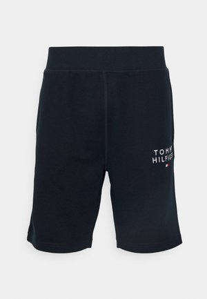 Shorts activos de algodón negro con una textura suave y una cinturilla elástica. Presenta un logo blanco con acentos rojos y azules en el lateral.