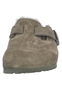 Zuecos de ante en color topo con dos correas ajustables y un forro suave y acolchado. La suela es de goma con un patrón de agarre texturizado.