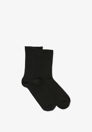 Schwarze Stricksocken mit glatter Textur, mittellange (bis zur Wade) Sockenlänge und verstärkten Zehen- und Fersenbereichen. Einfaches Design, keine sichtbaren Muster oder Akzente.
