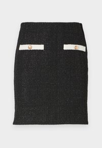 Mini-jupe noire texturée avec deux poches avant blanches décoratives, chacune avec un bouton doré.