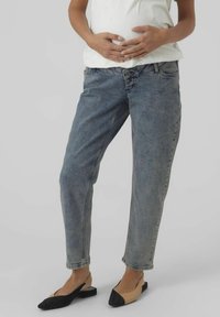 Jeans in denim blu con una vestibilità rilassata, gamba leggermente affusolata e design a cinque tasche. Indossati con ballerine in due tonalità, nere e nude.