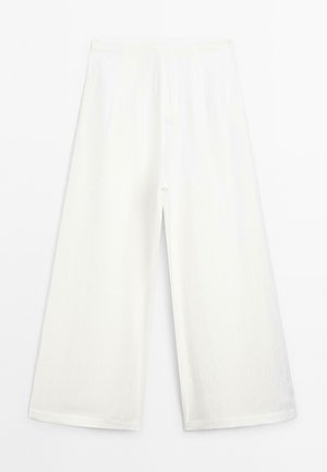 Pantalons larges blancs en tissu léger. Dotés d'une taille haute et d'une coupe droite avec une texture subtile. Pas de fermeture visible.