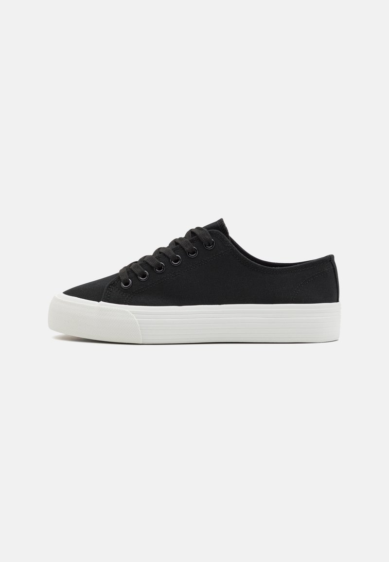 Schwarze Leinensneaker mit weißer Gummisohle, ausgestattet mit sechs Schnürlöchern und runder Zehenkappe. Einfaches Design mit minimalen Akzenten.