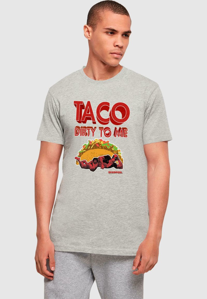 Pilkas medvilnės marškinėliai su ryškiai raudona užrašu "TACO DIRTY TO ME" ir spalvinga taco bei raudonai apsirengusio personažo grafika.