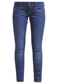 Jeans ajustados en denim azul oscuro, con una textura suave, diseño de cinco bolsillos y un pequeño logo de la marca en el bolsillo delantero.