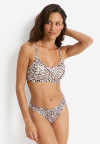Leoparddruck-Bikini-Set aus weichem, elastischem Stoff mit verstellbaren Trägern und schlichtem Design. Das Oberteil hat einen Rundhalsausschnitt und der Bikinihose sitzt niedrig auf der Hüfte.