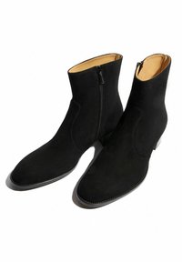 Botas de tobillo de ante negro con punta afilada, cremallera lateral, superficie texturizada y un leve tacón. El interior tiene un forro en contraste color marrón claro.
