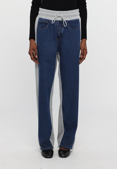 Denim joggers featuring a gray elastic waistband with drawstring, side gray panels, and a relaxed fit. Color scheme includes dark blue and gray.