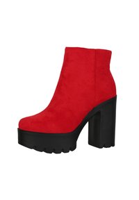 Botas de tobillo de ante rojo con una plataforma negra gruesa y un alto tacón cuadrado. Textura suave con punta redondeada y suela resistente.
