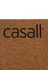 Korgipind, millel on rasvases mustas fondis tekst "casall". Pind on looduslik ja poorne, näidates heledat pruunikat värvi tumedate täppidega.