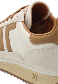 Baskets présentant un dessus en cuir blanc avec des accents et des coutures en suedine tan, une forme arrondie et une semelle en caoutchouc texturée avec la désignation 70.