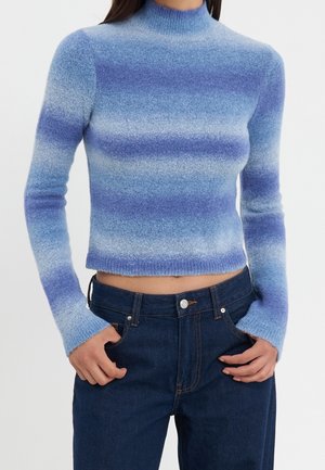 Blauer Ombre-Pullover mit hohem Kragen, langen Ärmeln und cropped Design. Hergestellt aus strukturiertem Strickmaterial, mit unterschiedlichen Blautönen.