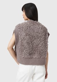 Maglione a maniche corte in morbido tessuto beige-marrone texturizzato con dettagli in filato a anelli sul retro e orlo a costine.