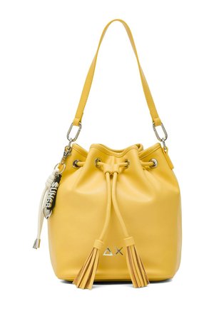 Gelbe Leder-Schultertasche mit Kordelzug-Quasten, einem einzelnen Schulterriemen, Metallösen und einem schwarz-weißen Schlüsselanhänger.