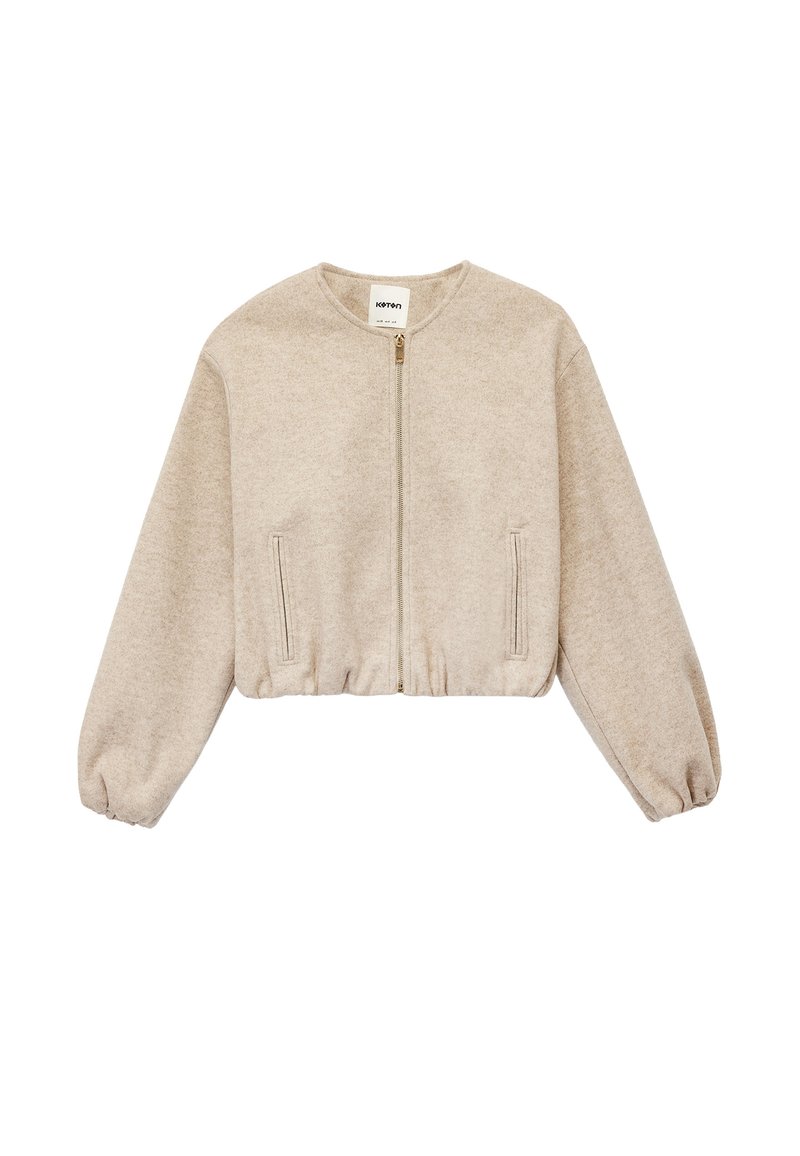 Beige cropped sweatshirt med lange, puffede ærmer, lynlås foran og sidelommer. Fremstillet af blødt, tekstureret stof med en afslappet pasform.