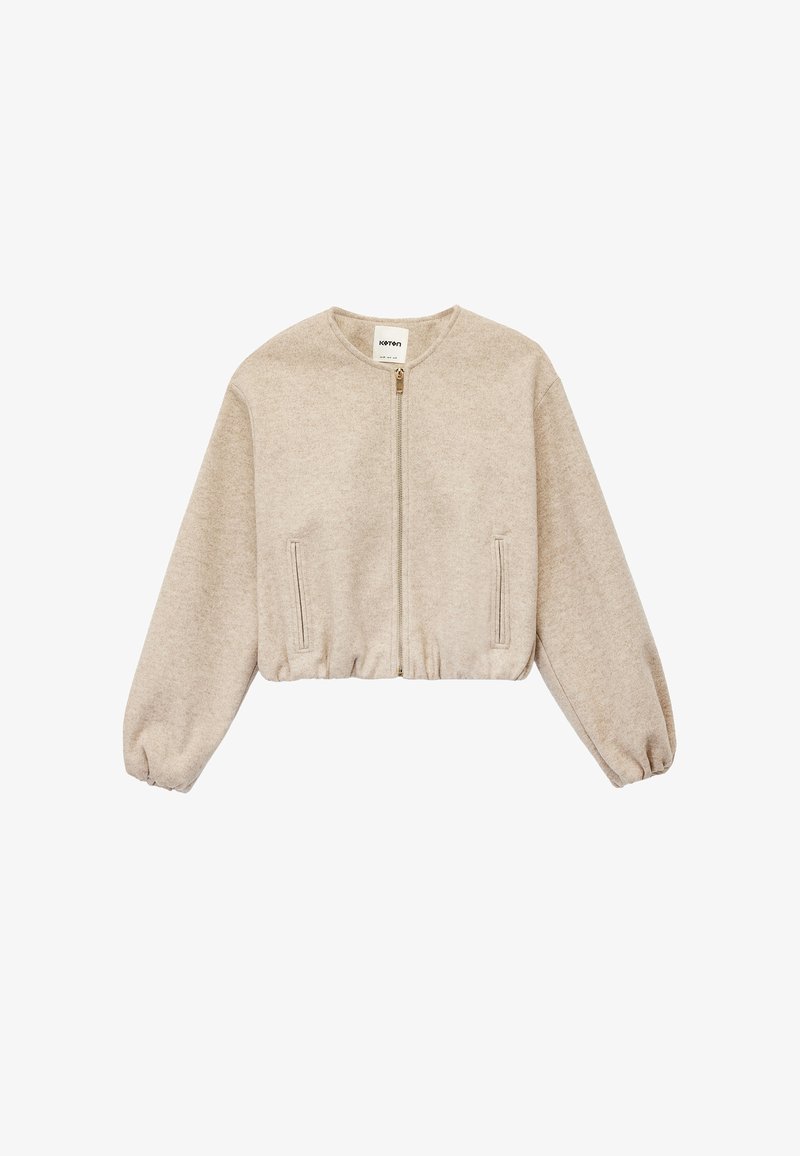 Beige cropped sweatshirt med lange, puffede ærmer, lynlås foran og sidelommer. Fremstillet af blødt, tekstureret stof med en afslappet pasform.