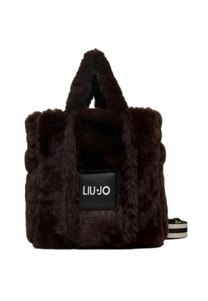 Borsa a tote in pelliccia sintetica marrone con doppio manico, caratterizzata da una toppa nera con logo e una tracolla a strisce aggiuntiva. Design testurizzato e morbido.