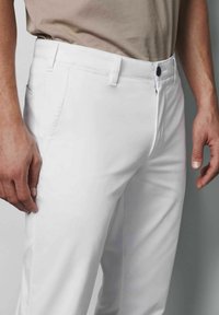 Witte katoenen broek met een slim fit, voorzakken en een knoopsluiting bij de taille, een gladde textuur en geen zichtbare patronen.