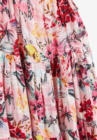 Robe fleurie en tissu léger, avec un fond rose et des motifs floraux rouges et jaunes, texture plissée et détail froncé.